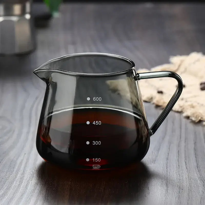 Fluted clear glass coffee pot with black handle and milliliter markings in a ribbed glass coffee carafe design