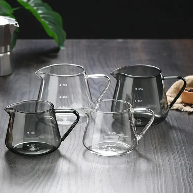 Set of four clear and dark-tinted glass coffee pots with black handles and measurement markings kitchen ribbed carafe