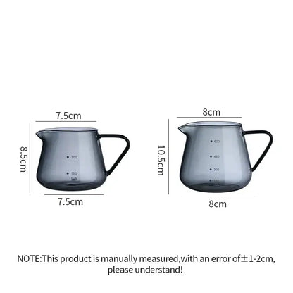 Two sleek dark gray glass coffee pots with black handles and precise volume markings in a fluted clear glass design