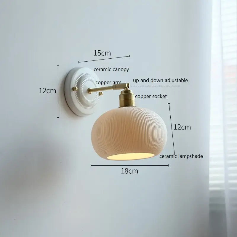 Fluted cream ceramic wall lamp with ribbed shade and brass accents ideal for bathroom decorbites ceramic wall lighting