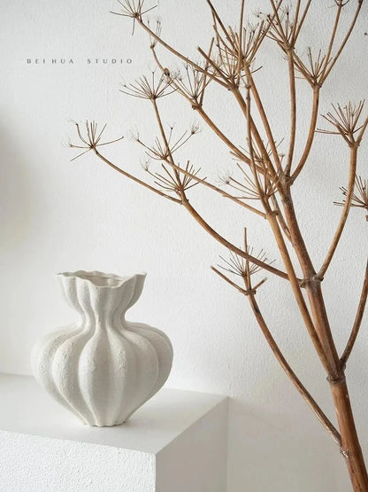 A white ceramic vase with fluted ribbed texture and organic shape for minimalist floral table centerpiece decor