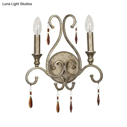Antique aged silver wall lamp with wrought iron design crystal deco and two candle-style bulbs for dining room