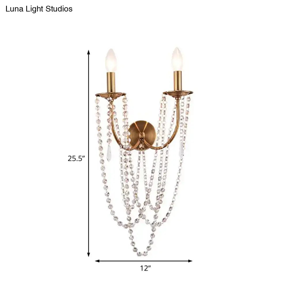 Antique brushed brass wall lamp featuring two lights with cascading clear crystal beads for bedroom use