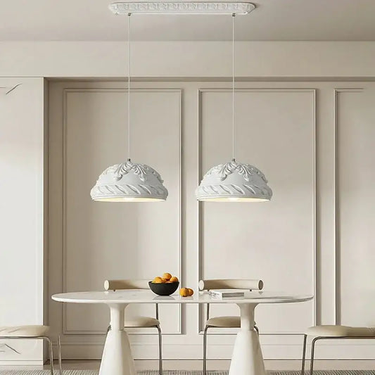 Two elegant french cream style led pendant lights with ornate domes hang above a minimalist dining table decorbites french cream