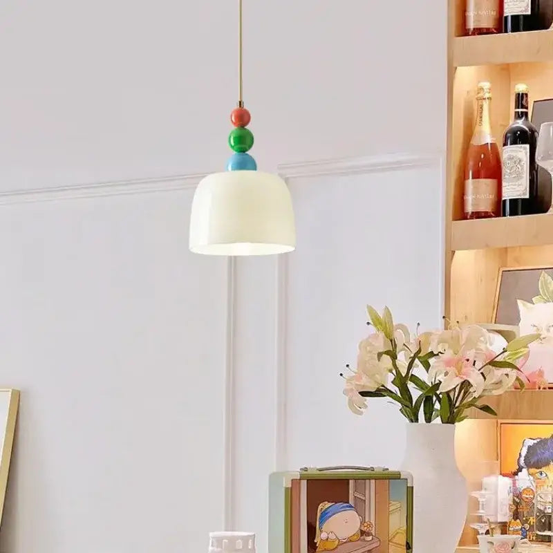 A cream style chandelier featuring a yellow ceramic pendant light with a white dome shade and colorful beads decorbites french cream