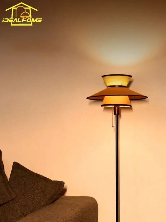 A sleek black floor lamp with a tiered amber shade featuring decorbites french design for living room decor