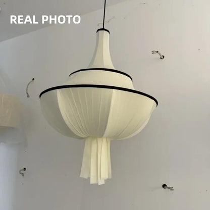 A modern off-white fabric decorbites creamy e27 foyer chandelier with black trim and tiered pleated design for bedroom light