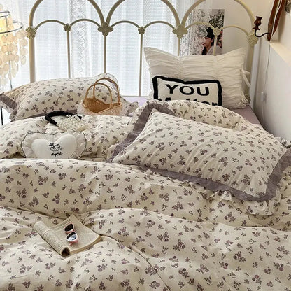 Cream-colored bedding set with double layer lace ruffles featuring delicate gray blossoms and ruffled edges