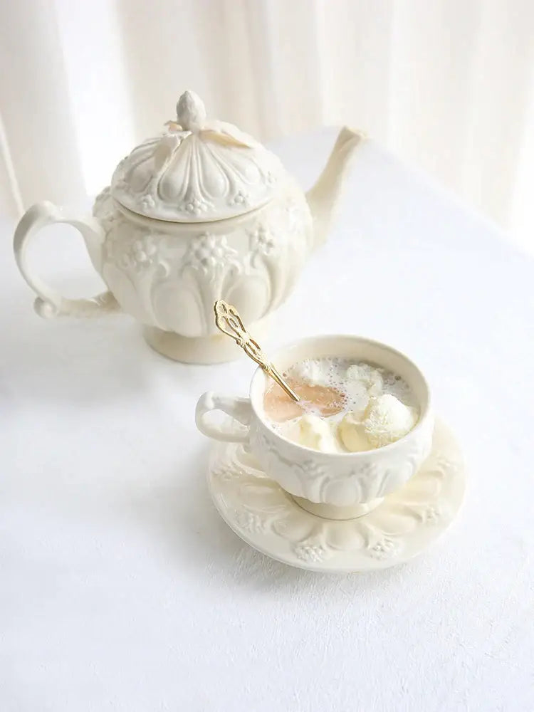 A festive white ceramic french garden cream tea cup filled with whipped cream topped with santa figurine and miniature tree