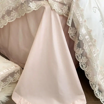 A soft blush pink satin bed canopy with delicate white lace trim and floral embroidery from decorbites french lace bedding set