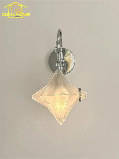 A clear faceted diamond-shaped glass wall lamp with polished chrome bracket in french medieval bauhaus style