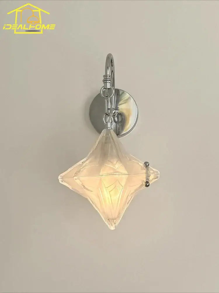 A clear faceted diamond-shaped glass wall lamp with polished chrome bracket in french medieval bauhaus style