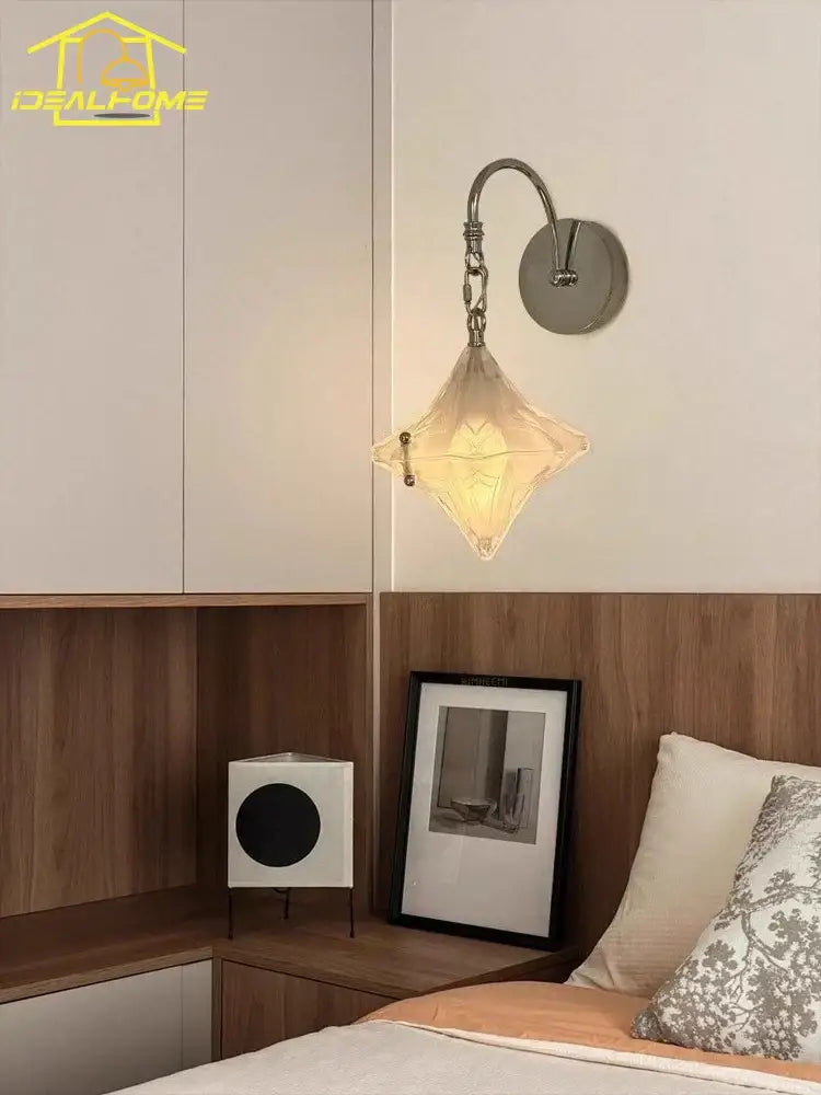 A french medieval bauhaus wall lamp featuring a warm diamond-shaped glass pendant with a chrome curved arm for living room