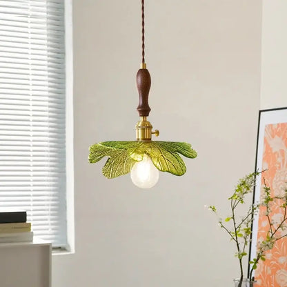 Delicate green glass pendant lamp with copper wood handle and brass accents for french minimalist dining room decorbites copper wood