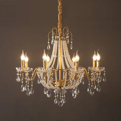 Gold-toned decorbites french pearl chandelier with six lit candle-style bulbs and crystal droplets for living room pendant lighting