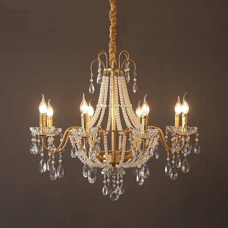 Gold-toned decorbites french pearl chandelier with six lit candle-style bulbs and crystal droplets for living room pendant lighting