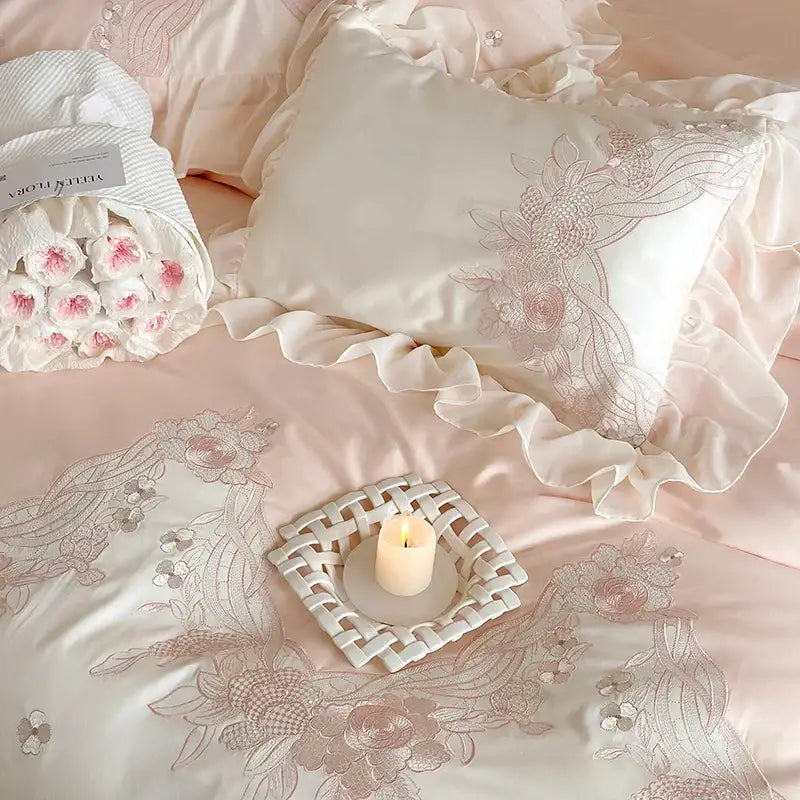 A delicate ivory satin pillow with ruffled edges and pink floral embroidery in decorbites french romantic lace ruffles bedding set