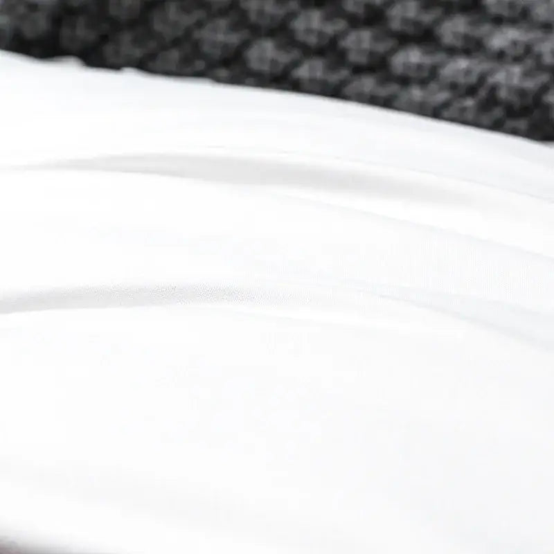 White cotton decorbites french ruffle pillow case with smooth fabric and subtle folds against textured black surface