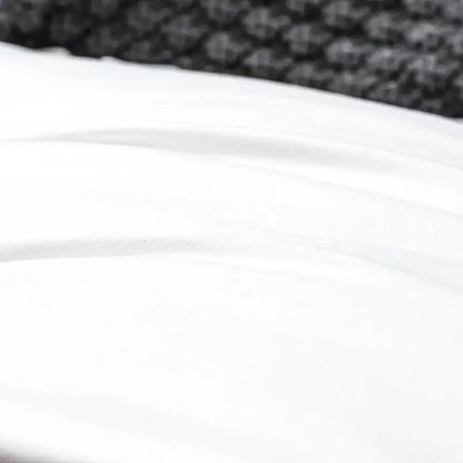 White cotton decorbites french ruffle pillow case with smooth fabric and subtle folds against textured black surface