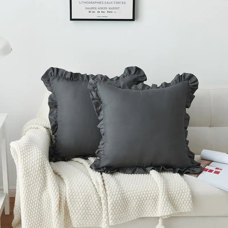 Two dark gray french ruffle pillow cases with smooth fabric finish on cream knitted blanket for bedroom decorbites french ruffle