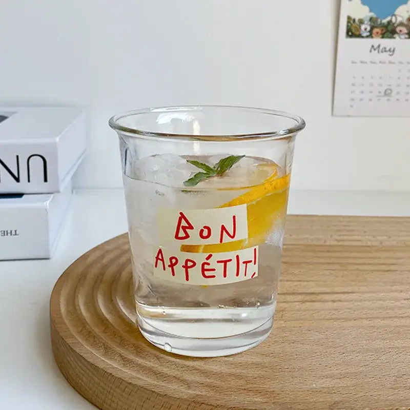Clear glass tumbler cup with bon appétit sticker filled with ice lemon and mint ideal as a kitchen juice glass