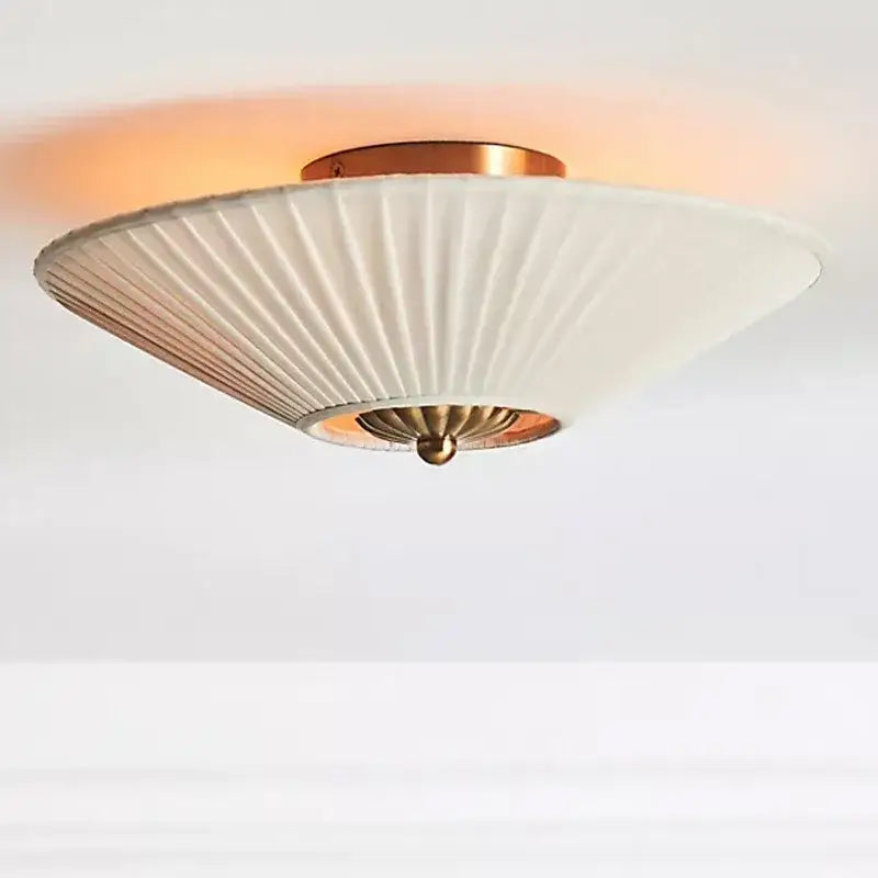 A modern ceiling lamp with white pleated fabric shade and brass accents for decorbites french style bedroom decor