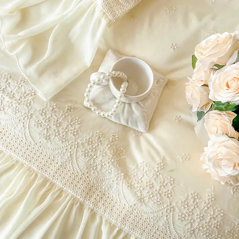 A delicate ivory lace-trimmed dress with intricate floral embroidery complements decorbites french vintage lace ruffles bedding set