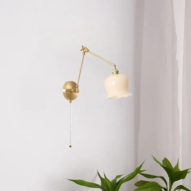 A brass wall-mounted reading lamp with cream resin led glass shade and adjustable arm for bedroom wall lights decorbites cream resin