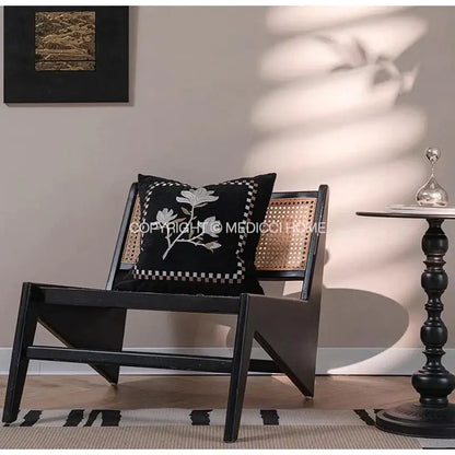 Black cushion with white floral embroidery and checkered border on black cane chair decorbites french vintage style