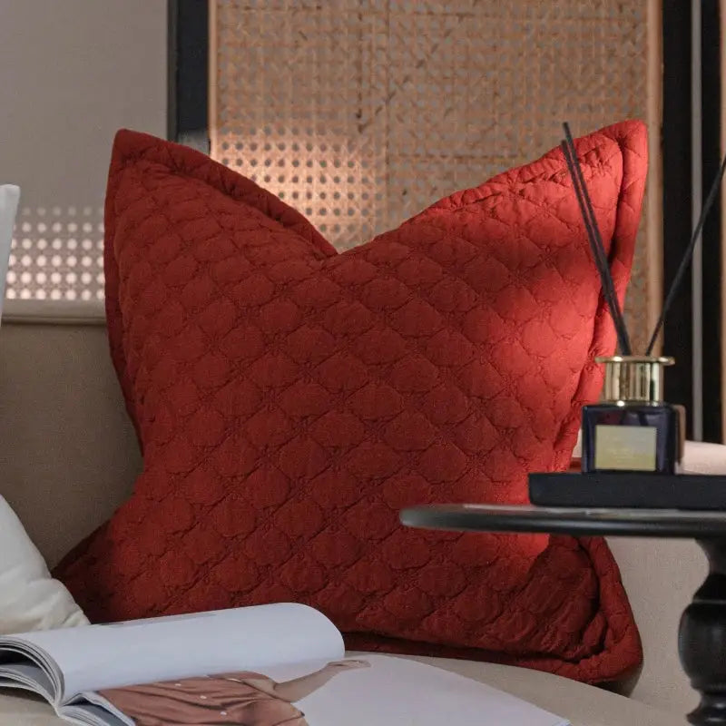 A plush rust-red quilted throw pillow with diamond stitch pattern complementing decorbites french vintage style
