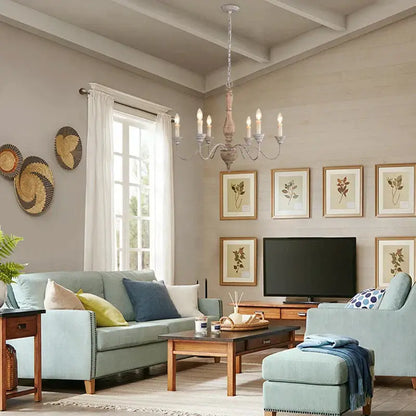 A rustic off-white french vintage wooden chandelier with six candle-style lights and a weathered wooden column for dining room decor