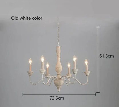Old white distressed french vintage wooden chandelier with five candle-style lights and chain suspension for dining room decor