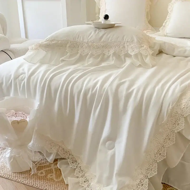 Cream-colored satin bedding set with french wedding lace ruffles and delicate floral embroidery by decorbites french wedding