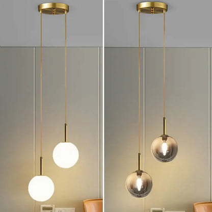 Modern brass-finished globe pendant light with frosted white and smoke gray glass shades for dining room use
