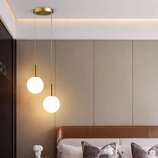 Two frosted white and smoke gray globe pendant lights with gold-toned fixtures for dining room pendant light decor