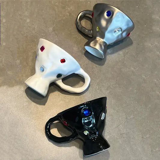 Three decorative gemstone setting ceramic mugs in white, metallic silver, and black for setting ceramic breakfast decorbites
