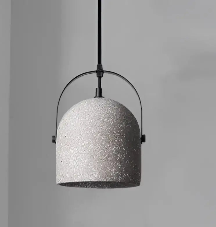 Geometric amber and cream glass pendant light with gray speckled concrete and black metal frame for dining room