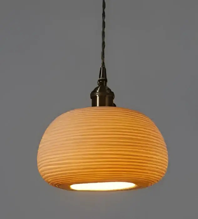 Geometric amber and cream glass pendant light with warm-toned ribbed ceramic and brass metal fixture for dining room