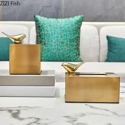 Gold-colored geometric animal brass color tissue box with minimalist design and small bird figurine for living room decor