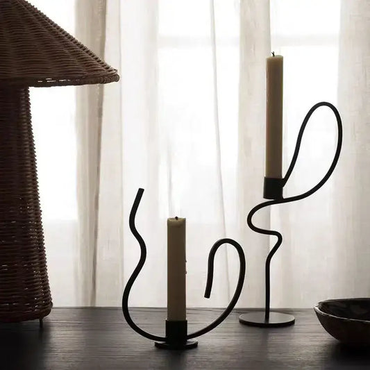 Black wrought iron candlestick candelabrum with elegant flowing curves and matte finish as decorbites geometric black centerpiece