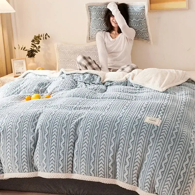 A cozy light blue quilted coral fleece flannel blanket with zigzag texture and white fleece trim for warm bedroom decorbites