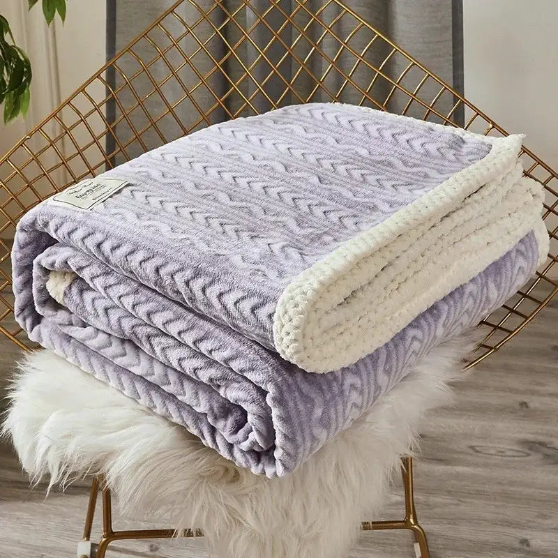 A plush lavender fleece flannel blanket with cream fleece lining folded on a gold chair for cozy bedroom decorbites coral fleece