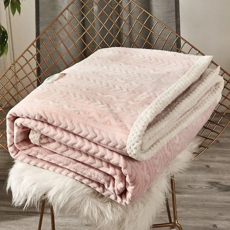 A soft pink and white plush throw blanket with textured chevron pattern made of coral fleece flannel for cozy decorbites use