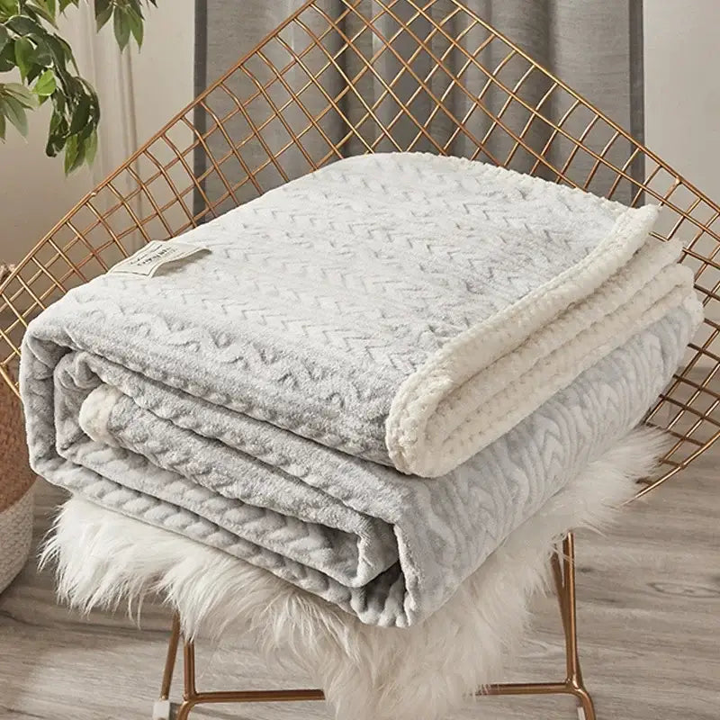 A soft light gray throw blanket with textured knit and plush fleece lining perfect for coral fleece flannel decorbites use