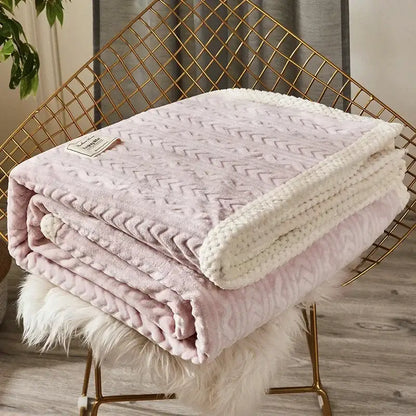A blush pink plush throw blanket with textured chevron pattern and cream knitted border made of coral fleece flannel