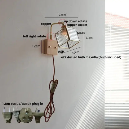 A modern wall light with copper-finished arm and clear glass cube shade featuring decorbites brass led wall bulb