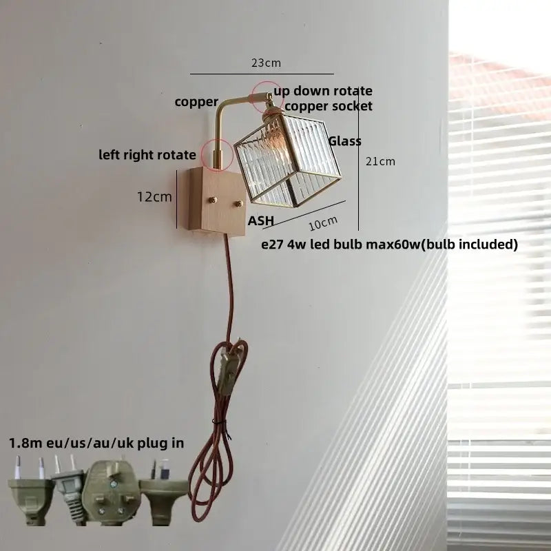 A modern wall light with copper-finished arm and clear glass cube shade featuring decorbites brass led wall bulb