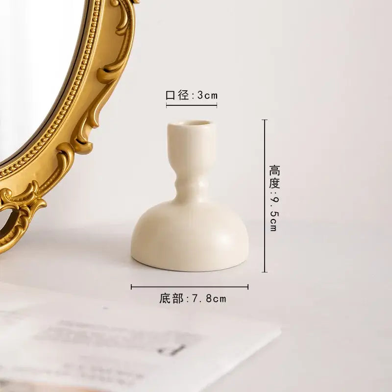 Cream-colored ceramic candle holder with smooth rounded base and slender neck for decorbites geometric ceramic decor
