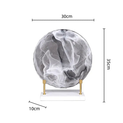Gray and white geometric disk marble sphere sculpture on minimalist gold-toned stand for home decor
