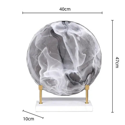 A 40cm wide geometric disk marble clear glass orb with gray and white patterns on a gold-toned stand for home decor